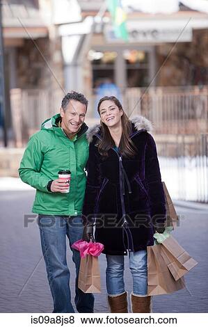 Young woman carrying shopping bags with mature man View Large Photo Image Stock Photo - Young woman carrying shopping bags with mature man. Fotosearch