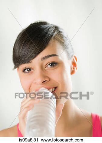 Young woman drinking from water bottle View Large Photo Image Stock Image - Young woman drinking from water bottle. Fotosearch