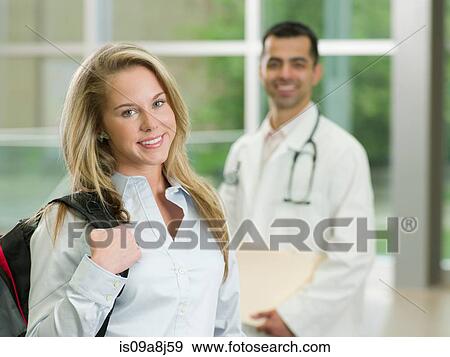 Stock Photo - Young woman holding backpack smiling, portrait. Fotosearch