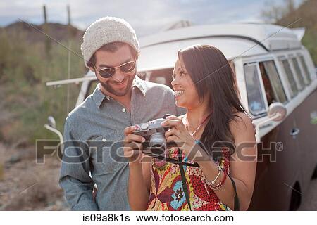 Young woman holding camera with boyfriend on road trip, smiling View Large Photo Image Stock Photograph - Young woman holding camera with boyfriend on road trip, smiling. Fotosearch