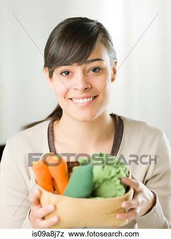 Young woman holding fresh vegetables, portrait View Large Photo Image Stock Photo - Young woman holding fresh vegetables, portrait. Fotosearch