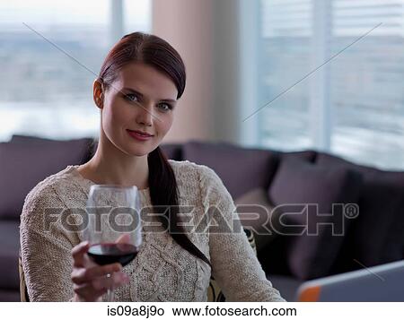Young woman holding glass of wine, portrait View Large Photo Image Picture - Young woman holding glass of wine, portrait. Fotosearch