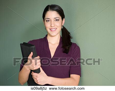 Young woman holding portfolio against green background View Large Photo Image Stock Photo - Young woman holding portfolio against green background. Fotosearch