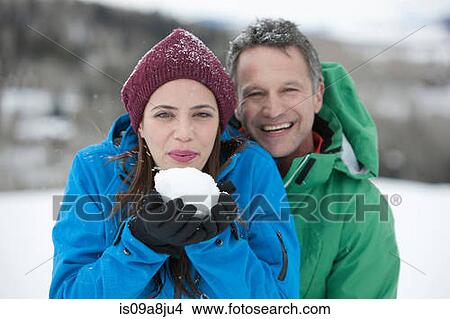 Young woman holding snowball with mature man, portrait View Large Photo Image Picture - Young woman holding snowball with mature man, portrait. Fotosearch
