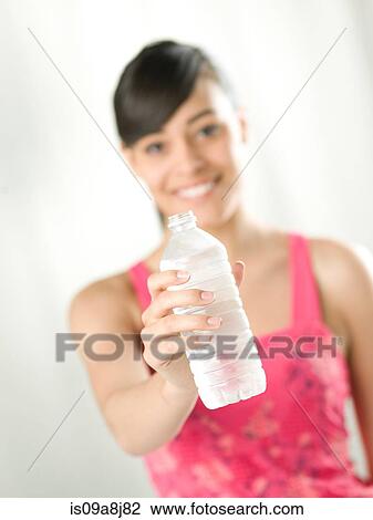 Young woman holding water bottle, close up View Large Photo Image Stock Image - Young woman holding water bottle, close up. Fotosearch
