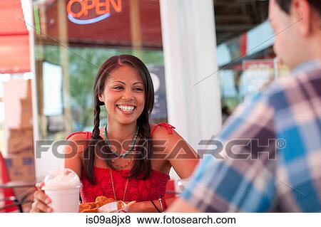 Stock Photo - Young woman in diner, smiling. Fotosearch