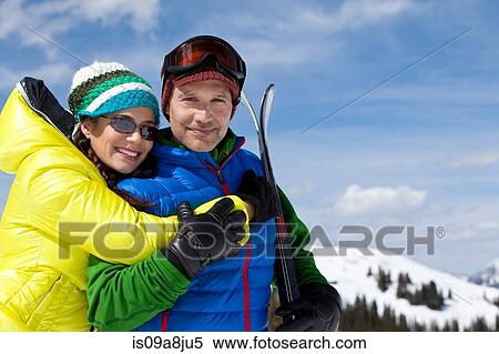 Young woman in skiwear embracing mature man holding skis, portrait View Large Photo Image Stock Photography - Young woman in skiwear embracing mature man holding skis, portrait. Fotosearch