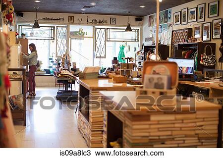 Stock Image - Young woman in vintage shop. Fotosearch
