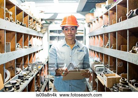 Young woman in warehouse with clipboard View Large Photo Image Stock Image - Young woman in warehouse with clipboard. Fotosearch