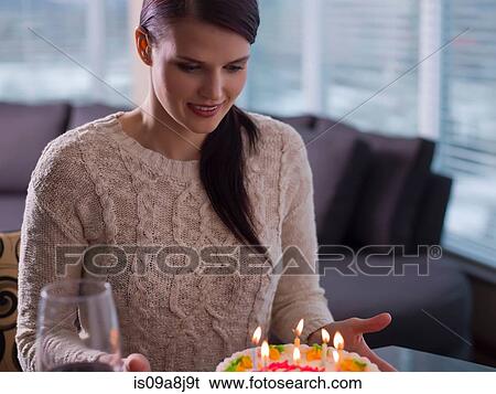 Young woman looking at birthday cake View Large Photo Image Stock Photograph - Young woman looking at birthday cake. Fotosearch