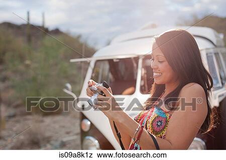 Young woman looking at camera on road trip, smiling View Large Photo Image Stock Photo - Young woman looking at camera on road trip, smiling. Fotosearch