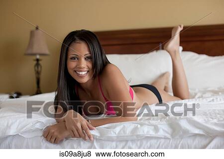 Young woman lying on bed in underwear, portrait View Large Photo Image Stock Photo - Young woman lying on bed in underwear, portrait. Fotosearch
