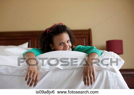 Stock Photograph - Young woman lying on bed. Fotosearch