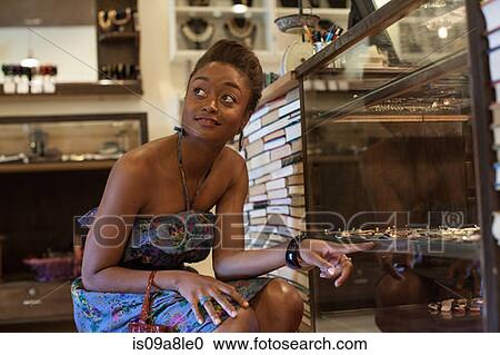 Young woman pointing at items in cabinet in vintage shop View Large Photo Image Stock Image - Young woman pointing at items in cabinet in vintage shop. Fotosearch