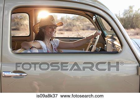 Young woman sitting in car on road trip, portrait View Large Photo Image Stock Photo - Young woman sitting in car on road trip, portrait. Fotosearch