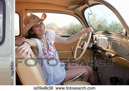 Young woman sitting in car on road trip, portrait View Large Photo Image Stock Photo - Young woman sitting in car on road trip, portrait. Fotosearch