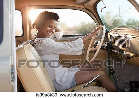 Young woman sitting in car on road trip, portrait View Large Photo Image Stock Photo - Young woman sitting in car on road trip, portrait. Fotosearch