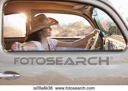 Young woman sitting in car on road trip, smiling View Large Photo Image Stock Photograph - Young woman sitting in car on road trip, smiling. Fotosearch