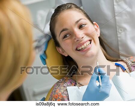 Stock Photography - Young woman smiling in dentist's chair. Fotosearch