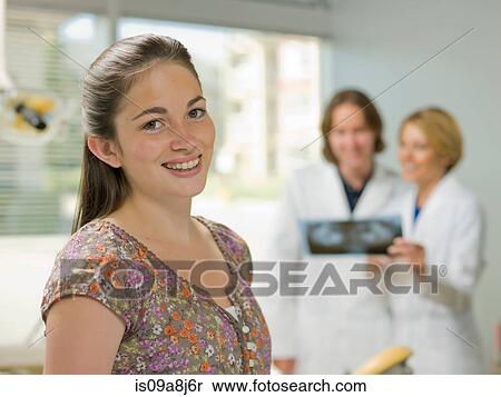 Stock Photography - Young woman smiling in dentist's office, portrait. Fotosearch