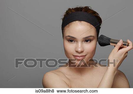 Young woman using blusher brush View Large Photo Image Stock Photo - Young woman using blusher brush. Fotosearch