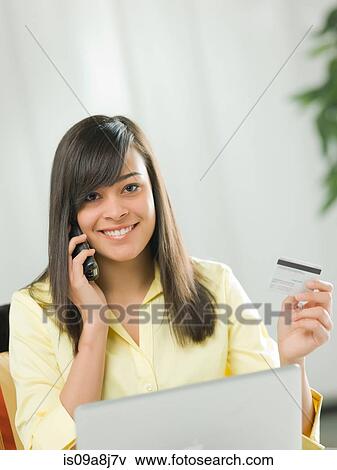 Young woman using credit card over the phone, portrait View Large Photo Image Stock Photo - Young woman using credit card over the phone, portrait. Fotosearch