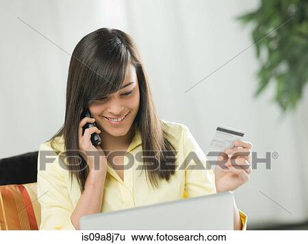 Young woman using credit card over the phone View Large Photo Image Stock Photograph - Young woman using credit card over the phone. Fotosearch