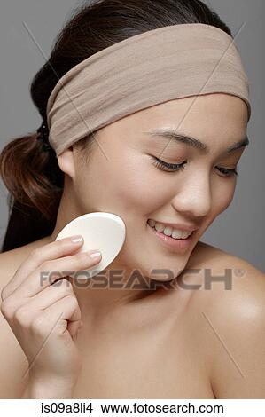 Young woman using make up sponge View Large Photo Image Picture - Young woman using make up sponge. Fotosearch