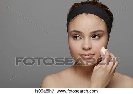 Young woman using make up sponge View Large Photo Image Stock Photo - Young woman using make up sponge. Fotosearch