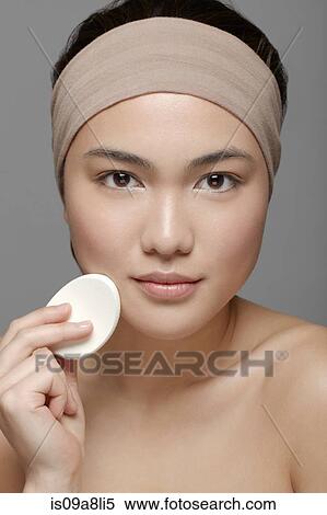 Young woman using make up sponge View Large Photo Image Stock Photography - Young woman using make up sponge. Fotosearch
