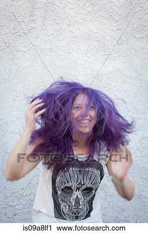 Stock Image - Young woman wearing purple wig. Fotosearch