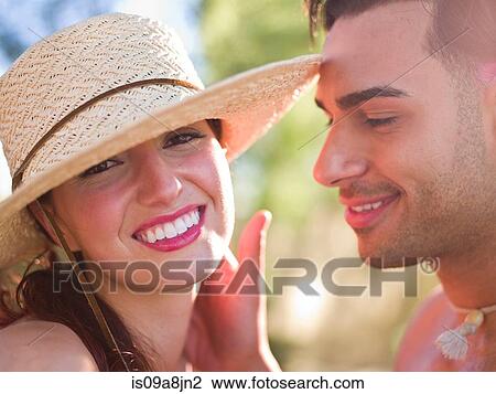 Stock Image - Young woman wearing sun hat and smiling, portrait. Fotosearch