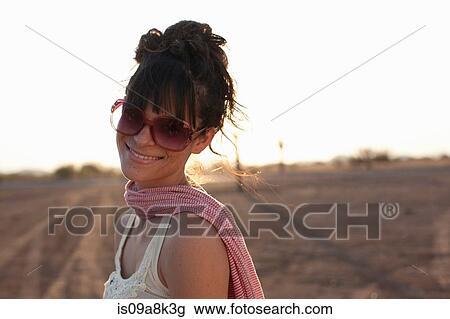 Young woman wearing sunglasses in desert, portrait View Large Photo Image Stock Image - Young woman wearing sunglasses in desert, portrait. Fotosearch