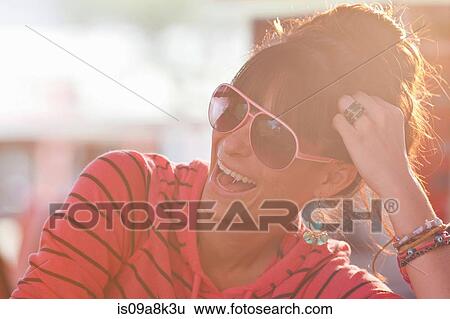 Young woman wearing sunglasses in sunlit diner View Large Photo Image Stock Photograph - Young woman wearing sunglasses in sunlit diner. Fotosearch