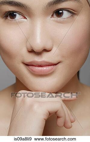 Stock Photo - Young woman with brown eyes looking away. Fotosearch
