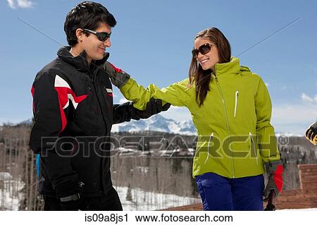 Stock Image - Young woman with ski instructor on ski slope. Fotosearch