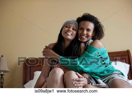 Young women embracing on bed, portrait View Large Photo Image Stock Image - Young women embracing on bed, portrait. Fotosearch