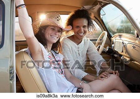 Young women sitting in car on road trip, portrait View Large Photo Image Stock Image - Young women sitting in car on road trip, portrait. Fotosearch