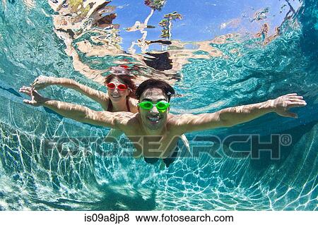 YYoung couple swimming underwater in pool View Large Photo Image Stock Photo - YYoung couple swimming underwater in pool. Fotosearch