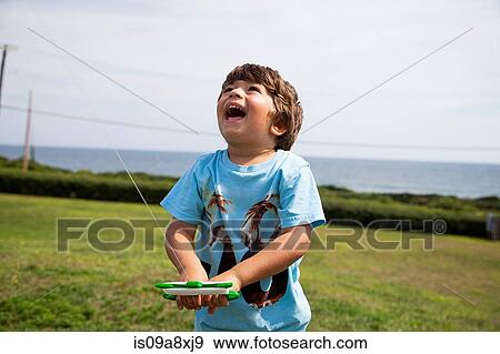 Stock Photo - Boy flying kite. Fotosearch