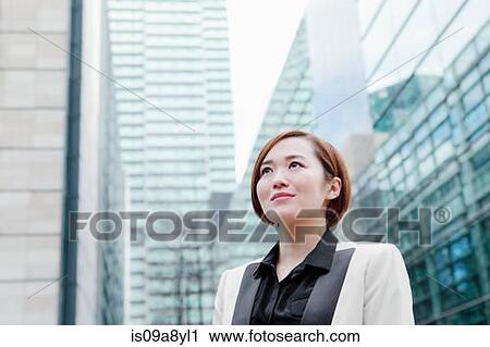 Stock Image - Close up of business woman looking into distance. Fotosearch