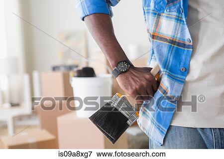 Stock Photo - Close-up of man holding paintbrush. Fotosearch