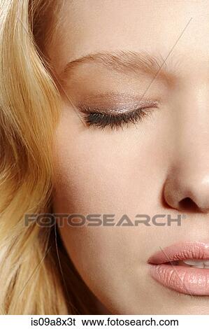 Stock Photograph - Close-up portrait of blonde woman with eyes closed. Fotosearch