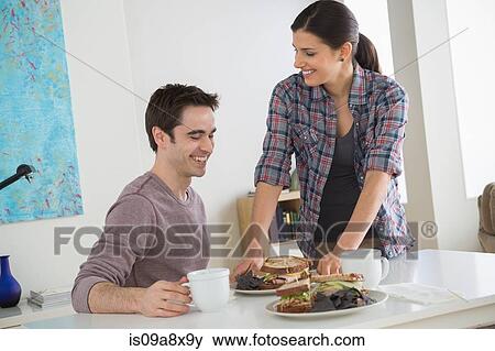 Couple at table with sandwiches View Large Photo Image Stock Photo - Couple at table with sandwiches. Fotosearch