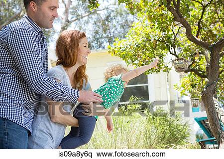 Stock Photography - Couple carrying child reaching out. Fotosearch