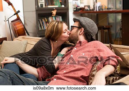 Couple kissing on sofa View Large Photo Image Picture - Couple kissing on sofa. Fotosearch
