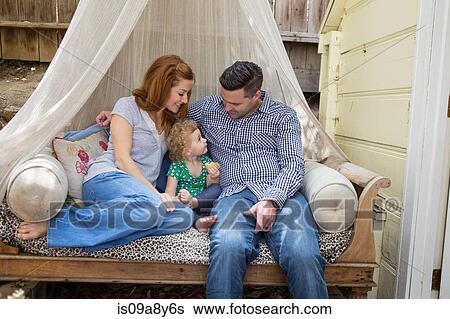 Couple on daybed with child View Large Photo Image Stock Photograph - Couple on daybed with child. Fotosearch