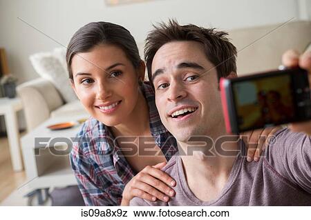 Stock Photo - Couple photographing themselves with camera phone. Fotosearch