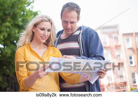 Stock Image - Couple reading map. Fotosearch