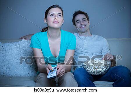 Couple watching television with popcorn View Large Photo Image Stock Photograph - Couple watching television with popcorn. Fotosearch